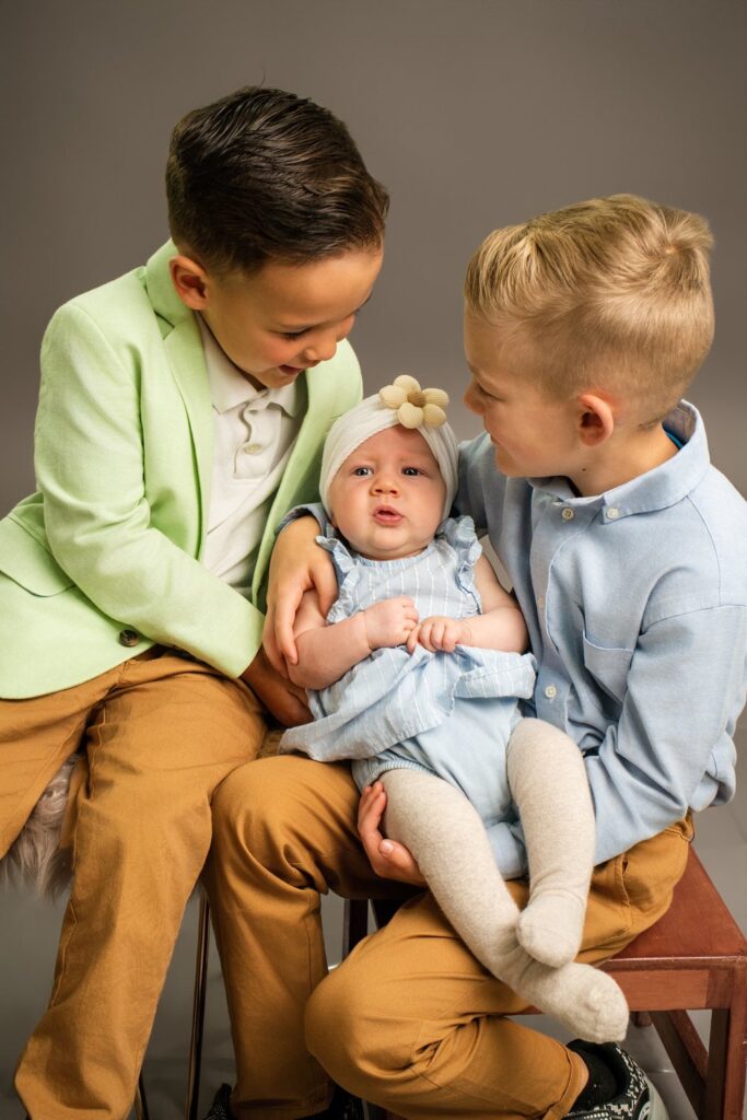 Niños con su bebé en una sesión de fotos familiar en estudio, Quito