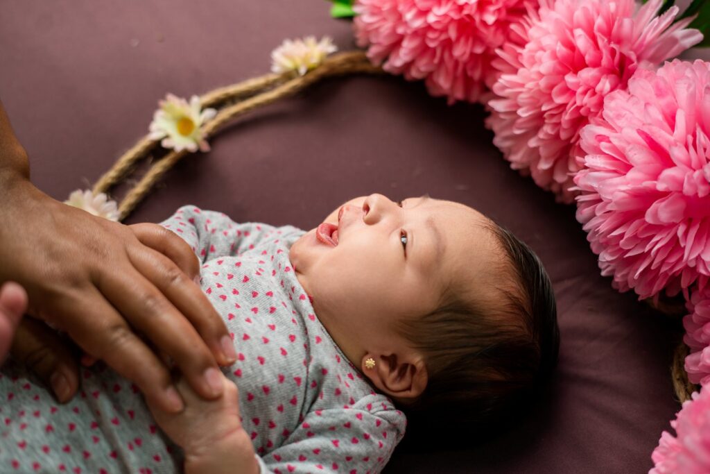 Recién nacido en una sesión newborn con flores en Calderón, Quito